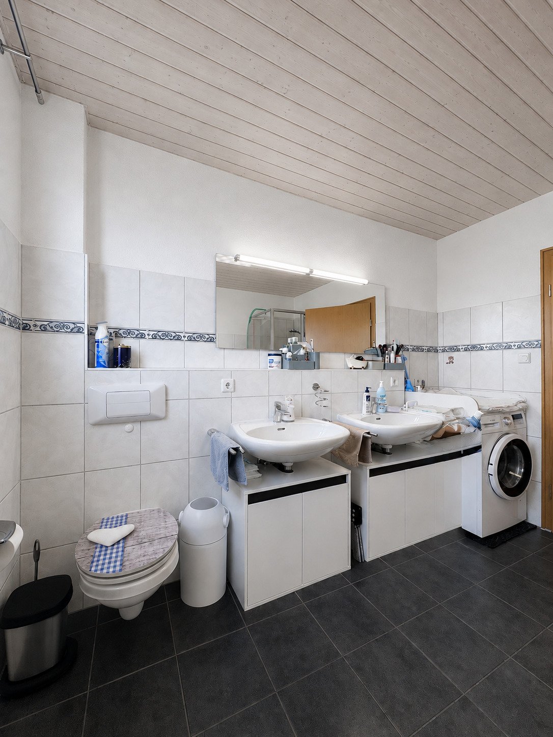 Hauptbad mit zwei Einzelwaschbecken, WC und Waschmaschinenanschluss